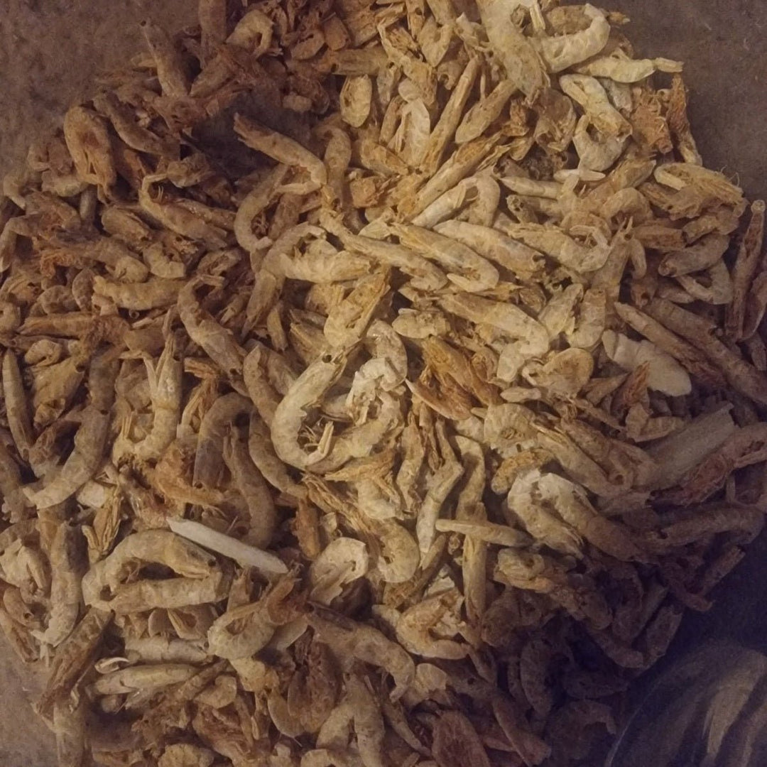 A heap of small dried shrimp, cream and tan in colour, filling a shallow round dish.