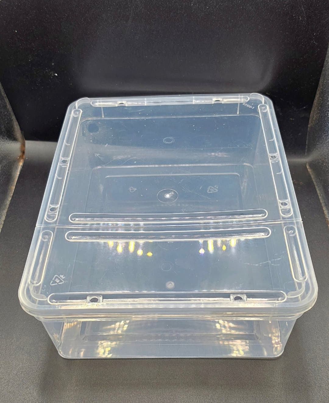 Clear plastic Braplast tub with its lid fitted, the two sliding vent strips set across one half of the lid.