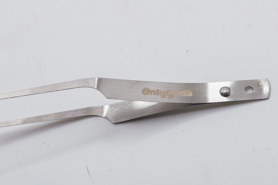 fully silver looking tweezers with onlypods logo in gold on side