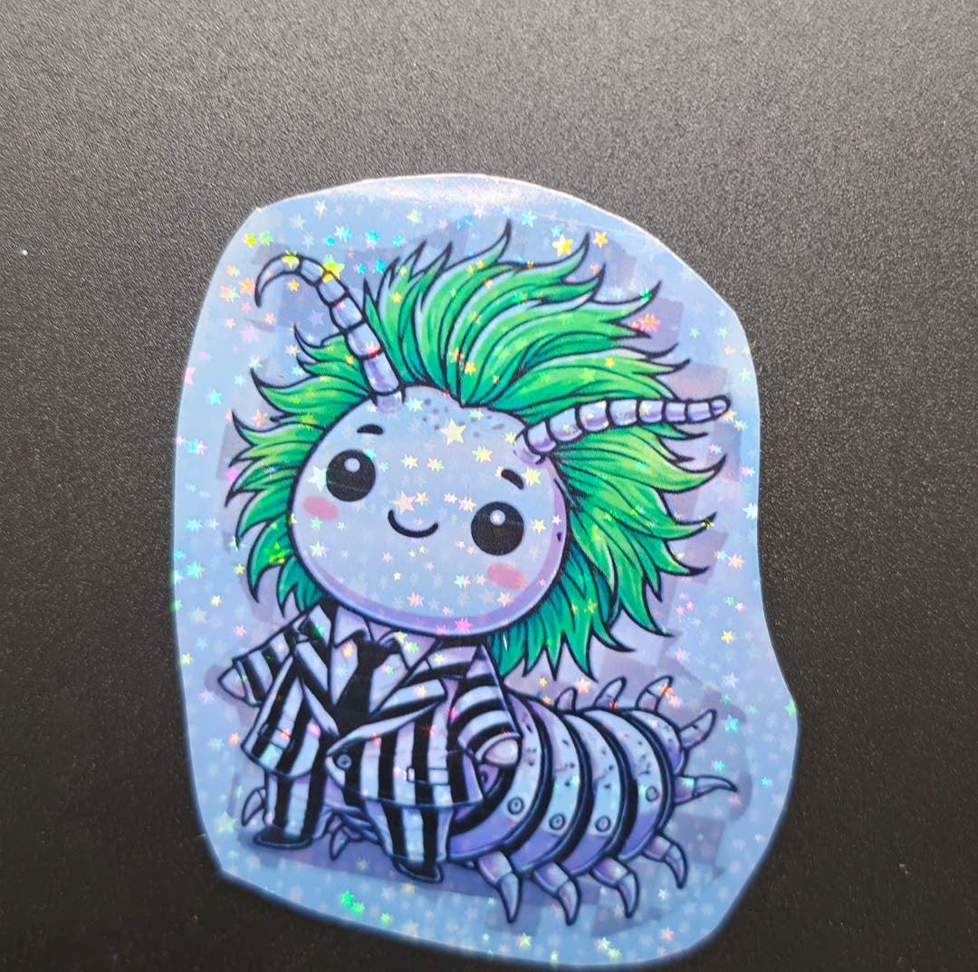 A glittery sticker of a smiling isopod with wild green hair and a black and white striped suit.