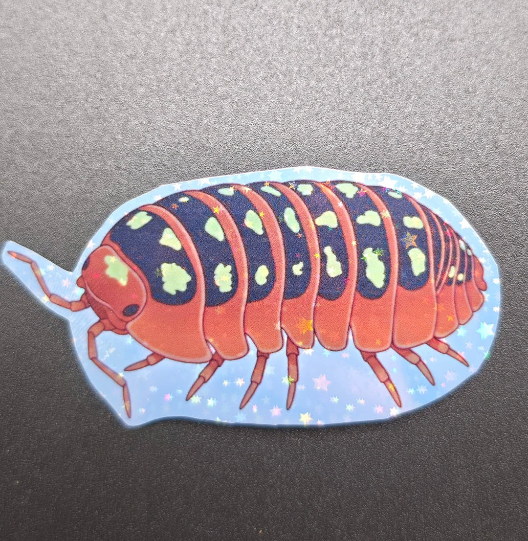 A single vinyl sticker of an orange isopod with a navy back and pale green spots on a starry blue ground.
